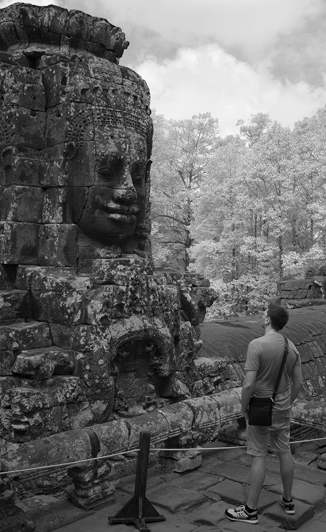 European Tourist Contemplating One of the Faces of Buddha, Bayon Temple.